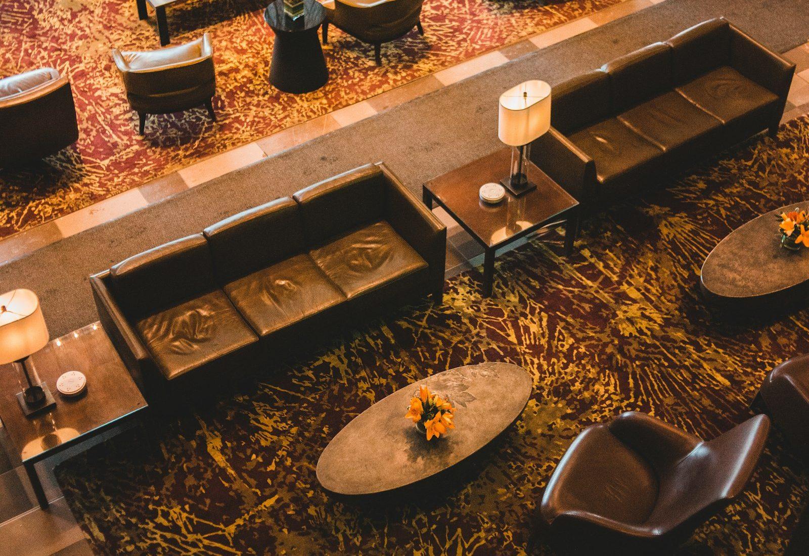 Aerial view of patterned rugs beneath seating in a modern hotel lobby
