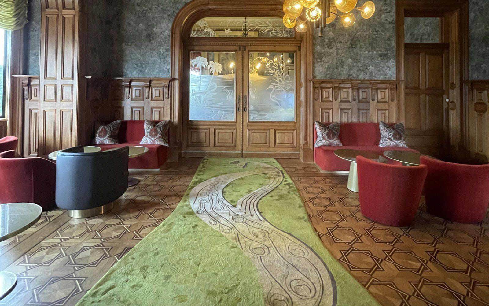 Runner rug down the center of a grand wood-paneled hall