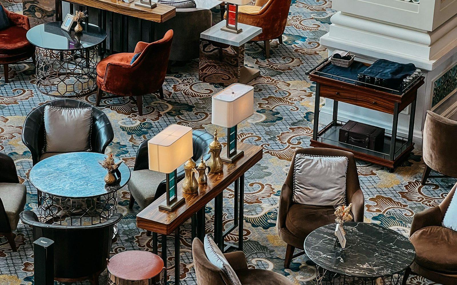 Jewel-toned patterned rug beneath lounge furniture in a hotel bar
