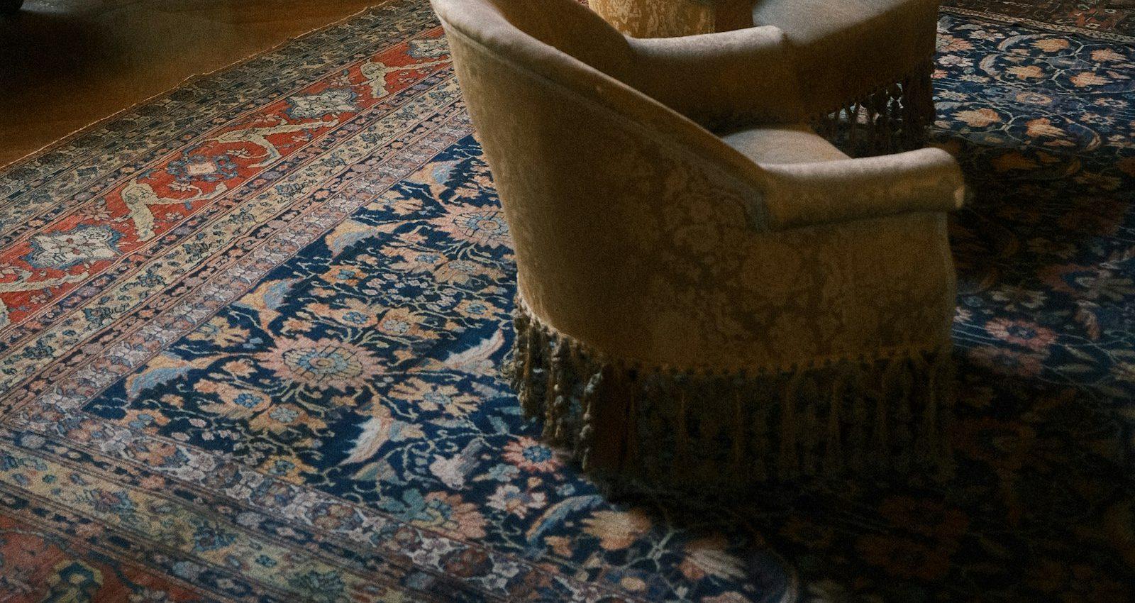 Ornate rug beneath armchairs in a wood-paneled manor library